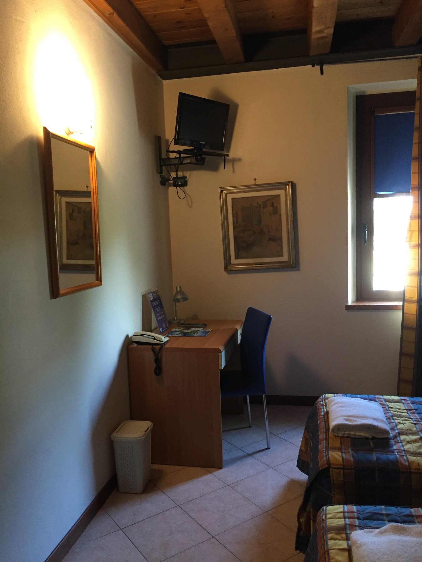 Lo scrittoio e il televisore a parete di una camera non ancora rinnovata