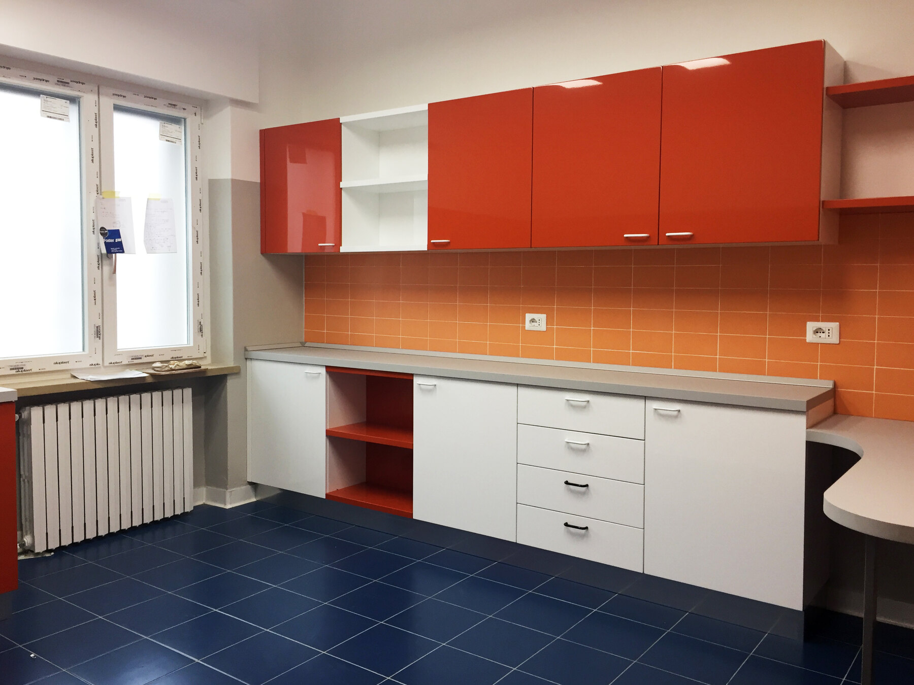 Gli arredi su misura dell’ambulatorio arancio, con pensili e piano di lavoro continuo