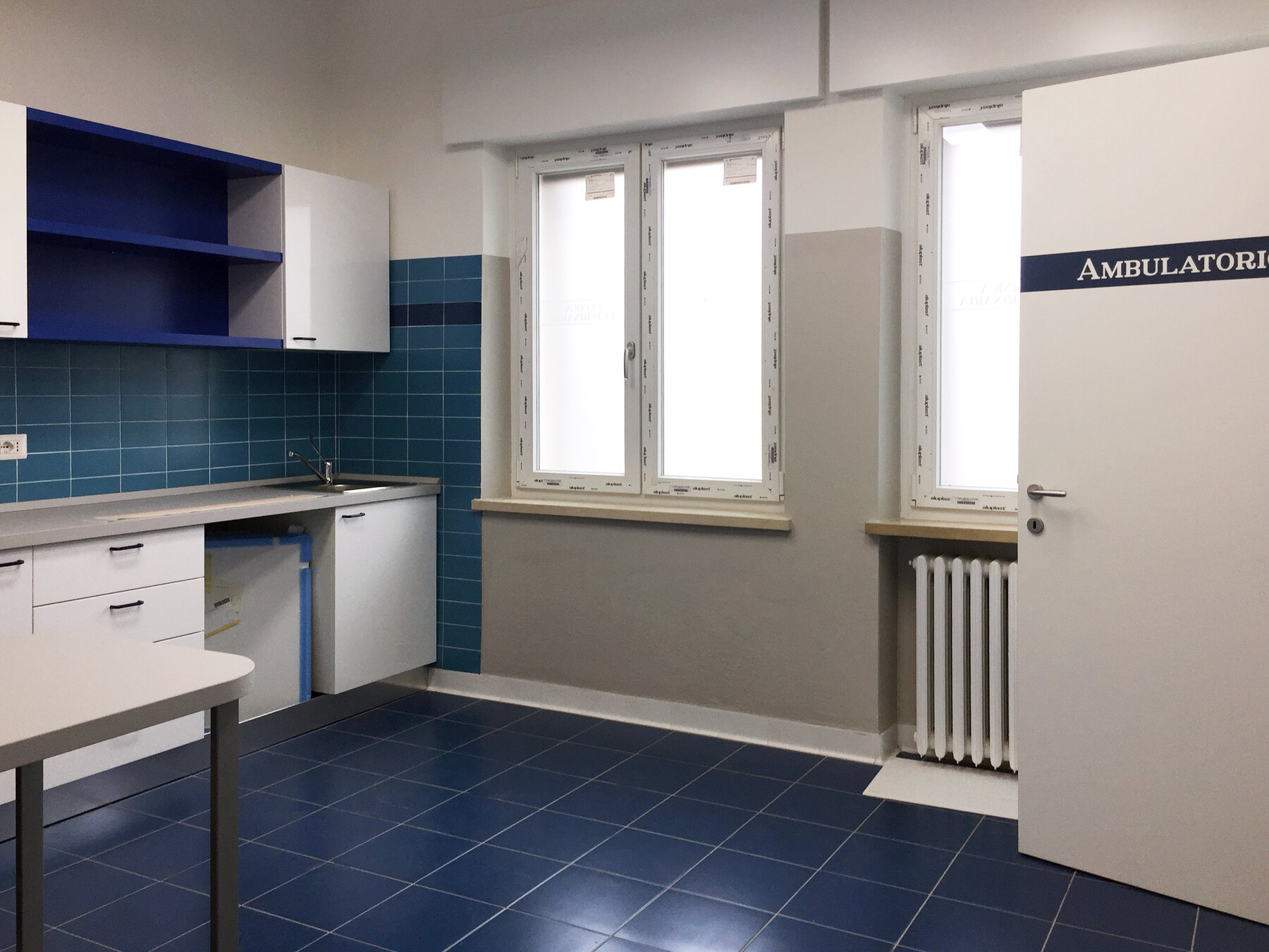 L’ambulatorio blu finito, con il banco di lavoro, il lavabo e il frigorifero dei farmaci