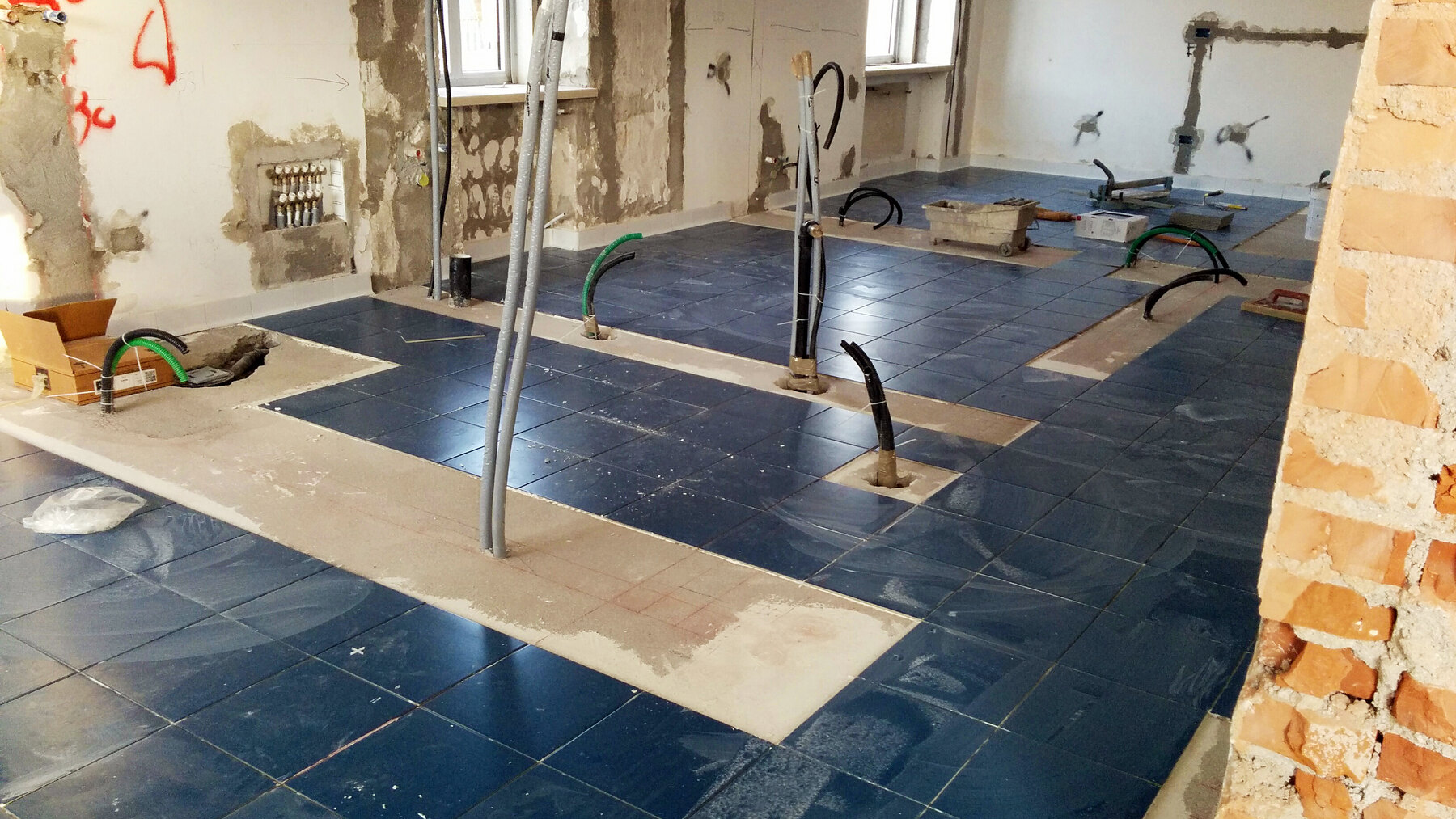 La posa del pavimento blu in gres attorno ai puntelli e ai punti di allaccio
