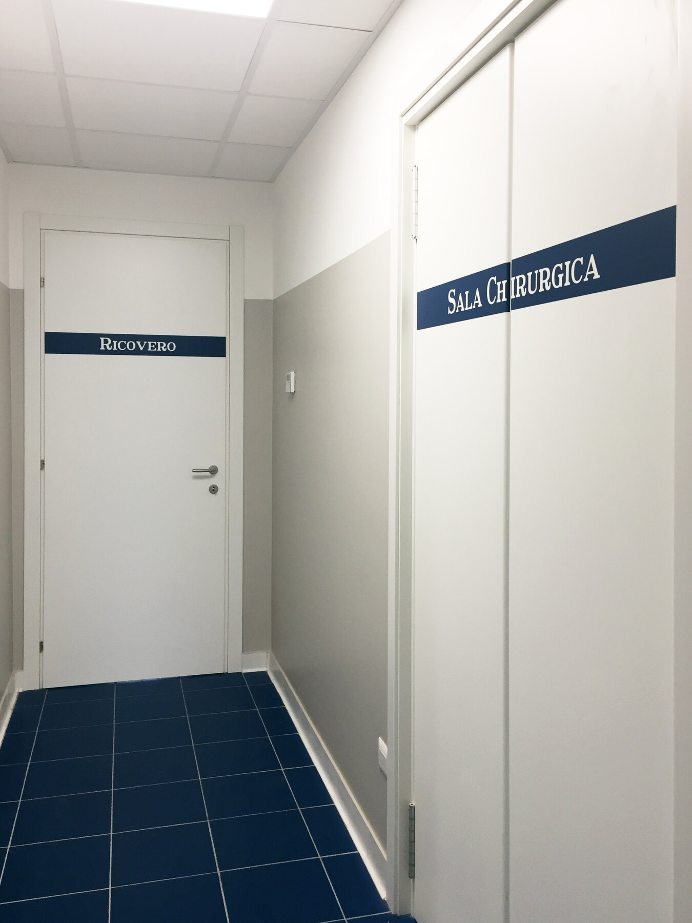 Le porte del ricovero e della sala chirurgica lungo il corridoio di servizio
