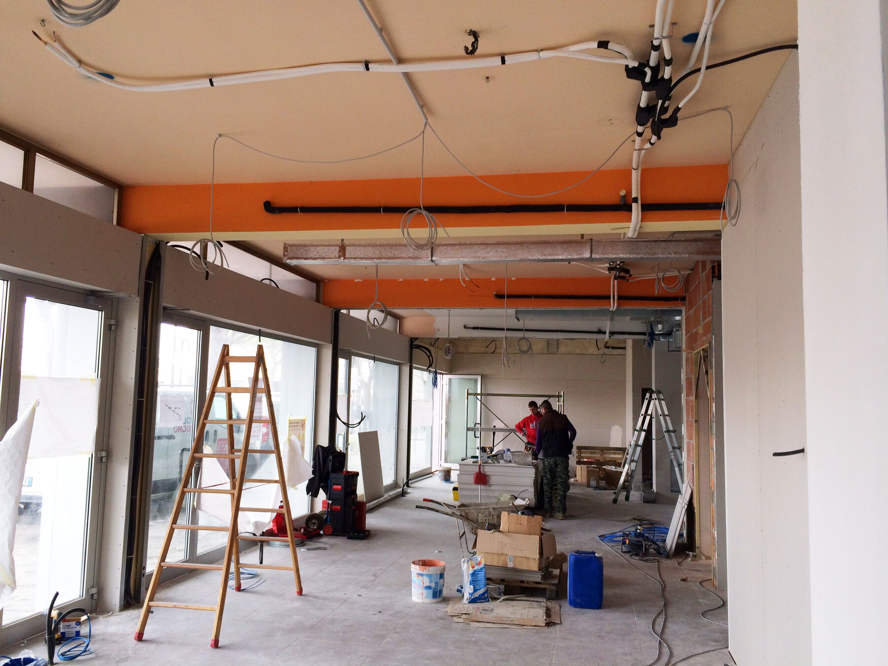 Cantiere: distribuzione degli impianti a soffitto lungo il fronte vetrato della futura filiale