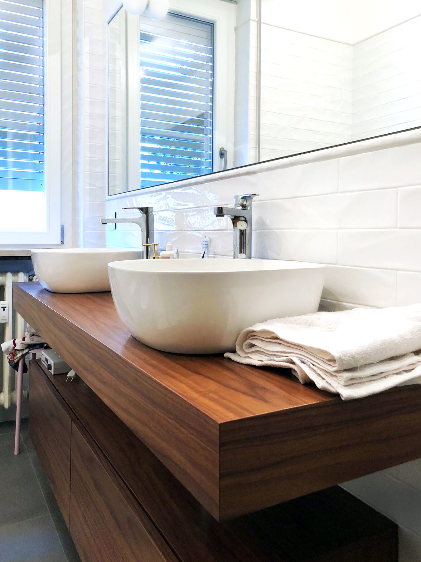 Il bagno padronale con doppio lavabo d’appoggio su mensolone in legno