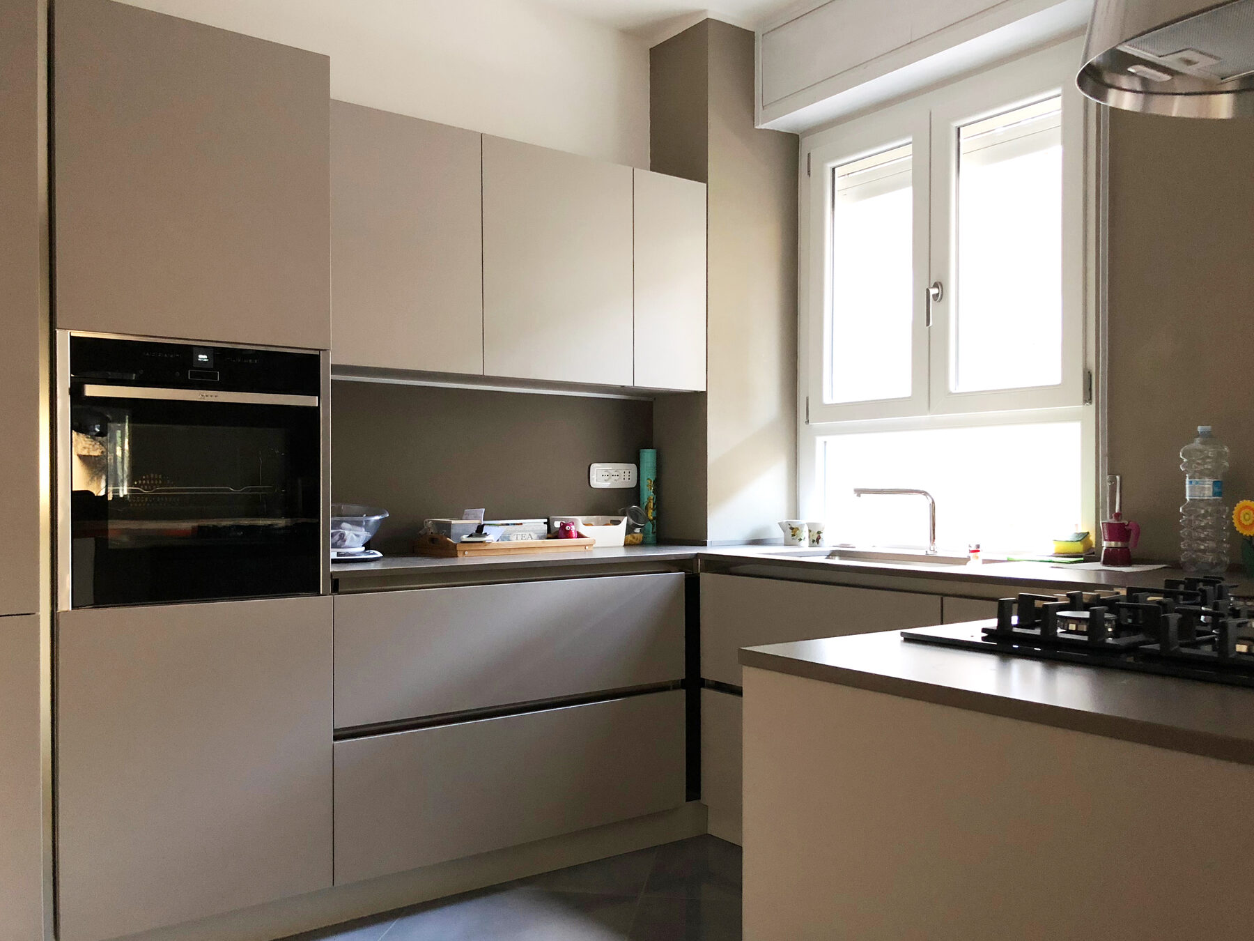 La nuova cucina con ante color tortora, forno a colonna e piano continuo