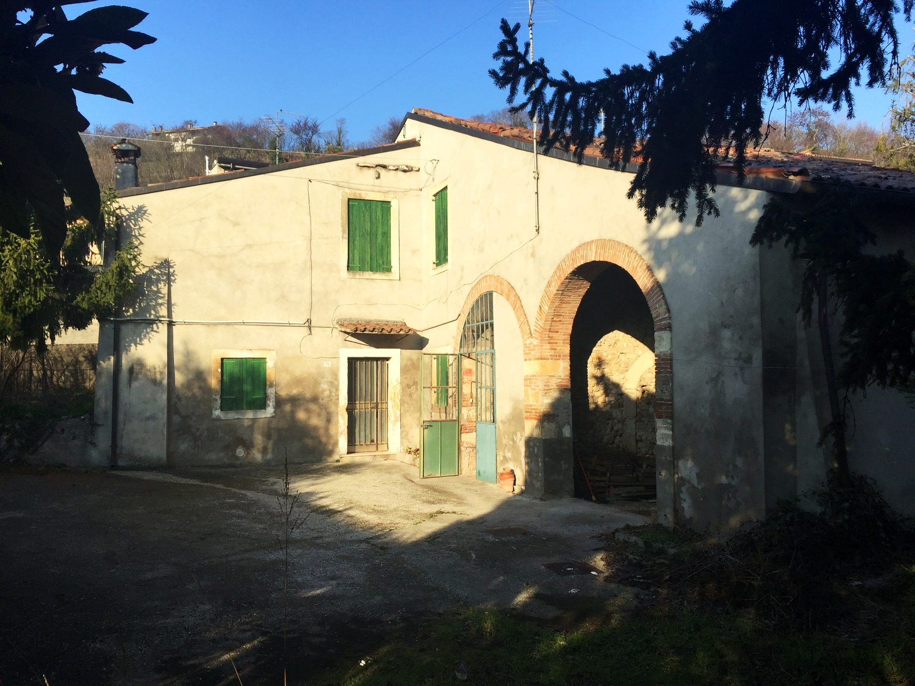 La corte rustica prima dell'intervento, con le persiane verdi e l'arcata della barchessa tamponata