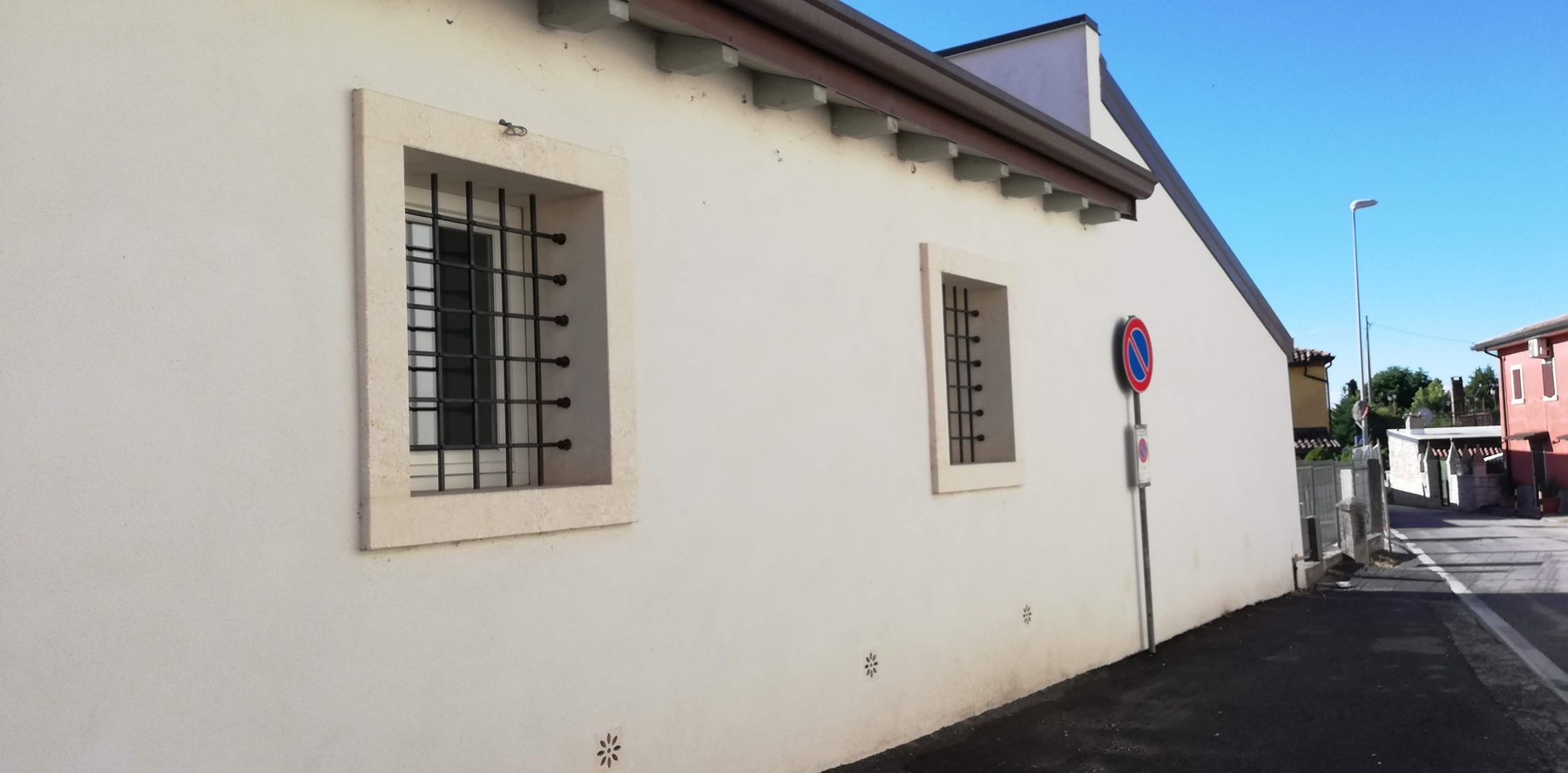 Il fronte su strada con le nuove finestre incorniciate in pietra e le inferriate